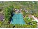 Aerial view of a tennis court nestled among lush trees, providing a private and scenic playing experience at 2239 Circlewood Dr # 17, Sarasota, FL 34231
