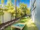 Lush backyard featuring tropical landscaping, a well-maintained lawn, and a fun cornhole game area at 2300 Avenue B, Bradenton Beach, FL 34217