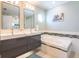 This modern bathroom includes double sinks, modern tiling accents, and a jetted bathtub at 2300 Avenue B, Bradenton Beach, FL 34217