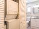 Bright bathroom features a toilet and vanity adjacent to a laundry closet with stacked washer and dryer at 2300 Avenue B, Bradenton Beach, FL 34217