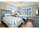 This colorful bedroom has 2 twin beds, wood floors, stylish quilts, and plenty of sunshine at 2300 Avenue B, Bradenton Beach, FL 34217
