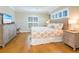 This bright bedroom offers hardwood floors, a ceiling fan, coastal decor, and plantation shutters at 2300 Avenue B, Bradenton Beach, FL 34217