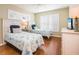 Bright bedroom with two twin beds, plantation shutters, hardwood floors, and a mounted TV at 2300 Avenue B, Bradenton Beach, FL 34217