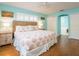 This relaxing bedroom has wood floors, a ceiling fan, wicker headboard, and ensuite bathroom with tub at 2300 Avenue B, Bradenton Beach, FL 34217