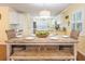 Dining room features a wood table with white chairs, bench, and a partial view of the kitchen at 2300 Avenue B, Bradenton Beach, FL 34217