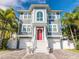 Charming two-story home with a red front door, white trim, and a brick paver driveway at 2300 Avenue B, Bradenton Beach, FL 34217