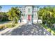 Charming two-story home featuring a red front door, a brick driveway, and a two-car garage at 2300 Avenue B, Bradenton Beach, FL 34217