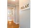 View of a hallway with wood floors that leads to a bathroom with a light wood 'RELAX' sign on the wall at 2300 Avenue B, Bradenton Beach, FL 34217