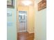 View of a hallway with hardwood floors leading to a bathroom with white cabinets and marble countertop at 2300 Avenue B, Bradenton Beach, FL 34217