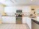 Bright kitchen features white cabinets, stainless steel appliances, and granite countertops at 2300 Avenue B, Bradenton Beach, FL 34217