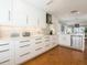 Bright kitchen features white cabinets, modern appliances, mosaic backsplash, and hardwood floors at 2300 Avenue B, Bradenton Beach, FL 34217