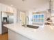 Bright, modern kitchen with white cabinets, stainless steel appliances, and white quartz countertops at 2300 Avenue B, Bradenton Beach, FL 34217