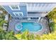 Aerial view of a pool and hot tub surrounded by a brick paver patio and palm trees at 2300 Avenue B, Bradenton Beach, FL 34217
