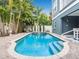 Beautiful private pool and hot tub with a paved patio and lush tropical landscaping in the background at 2300 Avenue B, Bradenton Beach, FL 34217