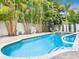 Inviting backyard pool with a spa and surrounding lush tropical landscaping for privacy and relaxation at 2300 Avenue B, Bradenton Beach, FL 34217