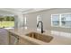 Bright kitchen featuring a large island with a stainless steel sink and black faucet at 2616 Star Apple Way, Sarasota, FL 34240