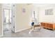 Bright bedroom with tile flooring, open bathroom, chair, and chest at 2830 Gypsy St, Sarasota, FL 34231
