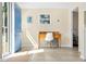 Bright entryway features tile flooring, desk, white chair, and blue entry door at 2830 Gypsy St, Sarasota, FL 34231