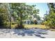 Inviting single-story home featuring a well-manicured lawn and mature trees at 2830 Gypsy St, Sarasota, FL 34231