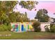 Charming single-story home featuring a blue door, green shutters, and lush landscaping, perfect for enjoying outdoor living at 2830 Gypsy St, Sarasota, FL 34231