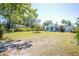 Expansive front yard with lush green grass and mature trees providing ample shade at 2830 Gypsy St, Sarasota, FL 34231