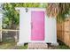 Charming outdoor shed with a whimsical pink door and white siding adding character to the property at 2830 Gypsy St, Sarasota, FL 34231