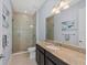 Bathroom with dark cabinets, a granite countertop and glass-enclosed shower at 315 Sapphire Lake Dr # 202, Bradenton, FL 34209