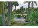 Hammock hung between palm trees offers a relaxing spot amid lush tropical landscaping at 315 Sapphire Lake Dr # 202, Bradenton, FL 34209