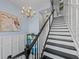 Beautiful staircase featuring hardwood steps, white risers, and a decorative chandelier above at 315 Sapphire Lake Dr # 202, Bradenton, FL 34209