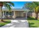 Exterior view of home with covered parking and cozy seating area with lush lawn at 3458 Lalani Blvd, Sarasota, FL 34232