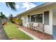 Home's exterior shows cozy seating and manicured lawn, creating a welcoming curb appeal at 3458 Lalani Blvd, Sarasota, FL 34232