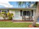 Close-up of front entrance with cozy seating area, enhanced by lush landscaping at 3458 Lalani Blvd, Sarasota, FL 34232