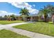 Charming single-story home featuring a well-maintained lawn, driveway, and lush tropical landscaping at 3458 Lalani Blvd, Sarasota, FL 34232