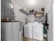 Functional laundry room with a washer, dryer, water heater and shelving at 3458 Lalani Blvd, Sarasota, FL 34232