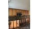 Kitchen features wood cabinets, stone backsplash, stainless steel microwave, and unfinished flooring at 3808 118Th W St, Bradenton, FL 34210