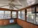 Enclosed sun room featuring wood paneled walls, multiple windows, and ceiling fan at 3808 118Th W St, Bradenton, FL 34210