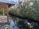 A waterfront scene featuring a wooden deck and calm canal with lush vegetation at 3808 118Th W St, Bradenton, FL 34210