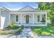Inviting front porch with classic columns, a cozy swing, and beautifully landscaped surroundings at 3925 Bell Ave, Sarasota, FL 34231