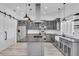 Bright kitchen featuring a center island, gray cabinets, stainless steel appliances, and a farmhouse sink at 3925 Bell Ave, Sarasota, FL 34231