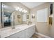 Well-lit bathroom with double sinks, a large mirror, and neutral colored walls at 4208 Central Sarasota Pkwy # 1422, Sarasota, FL 34238