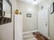 Well-lit hallway with a decorative mirror, white shelving unit, and patterned rug by the door at 4208 Central Sarasota Pkwy # 1422, Sarasota, FL 34238