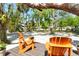 Inviting backyard deck featuring orange Adirondack chairs and views of mature trees and greenery, creating a peaceful retreat at 433 N Osprey Ave, Sarasota, FL 34236