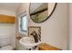 Compact bathroom with a wall mounted sink, a circular mirror, and a toilet at 433 N Osprey Ave, Sarasota, FL 34236