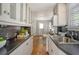A well-lit kitchen is features white cabinets, black countertops and stainless steel appliances at 433 N Osprey Ave, Sarasota, FL 34236