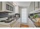 Well-lit kitchen with white cabinets, a black tile backsplash, and an oven and microwave appliances at 433 N Osprey Ave, Sarasota, FL 34236