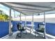 Charming covered patio featuring comfortable seating, a small table, and blue privacy screens, ideal for relaxing outdoors at 433 N Osprey Ave, Sarasota, FL 34236