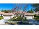 Charming villa with a well-maintained lawn, beautiful landscaping, and a terracotta tiled roof under a clear blue sky at 4341 Callista Ln, Sarasota, FL 34243