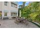 Backyard patio with a dining set, mature landscaping, and exterior of the home featuring windows with awnings at 4607 5Th Ne Ave, Bradenton, FL 34208
