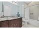 Bathroom vanity with granite countertop, dark wood cabinets, framed mirror, shower and tub combo at 4607 5Th Ne Ave, Bradenton, FL 34208