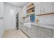 A laundry room featuring gray cabinets, granite countertops, stacked washer/dryer, and modern design at 4607 5Th Ne Ave, Bradenton, FL 34208